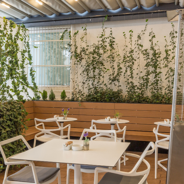Tall pyramid-style patio heater warming an outdoor dining patio with white furniture