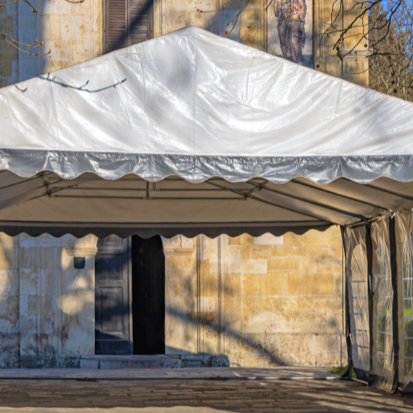 White frame tent set up at the entrance of an old stone church building