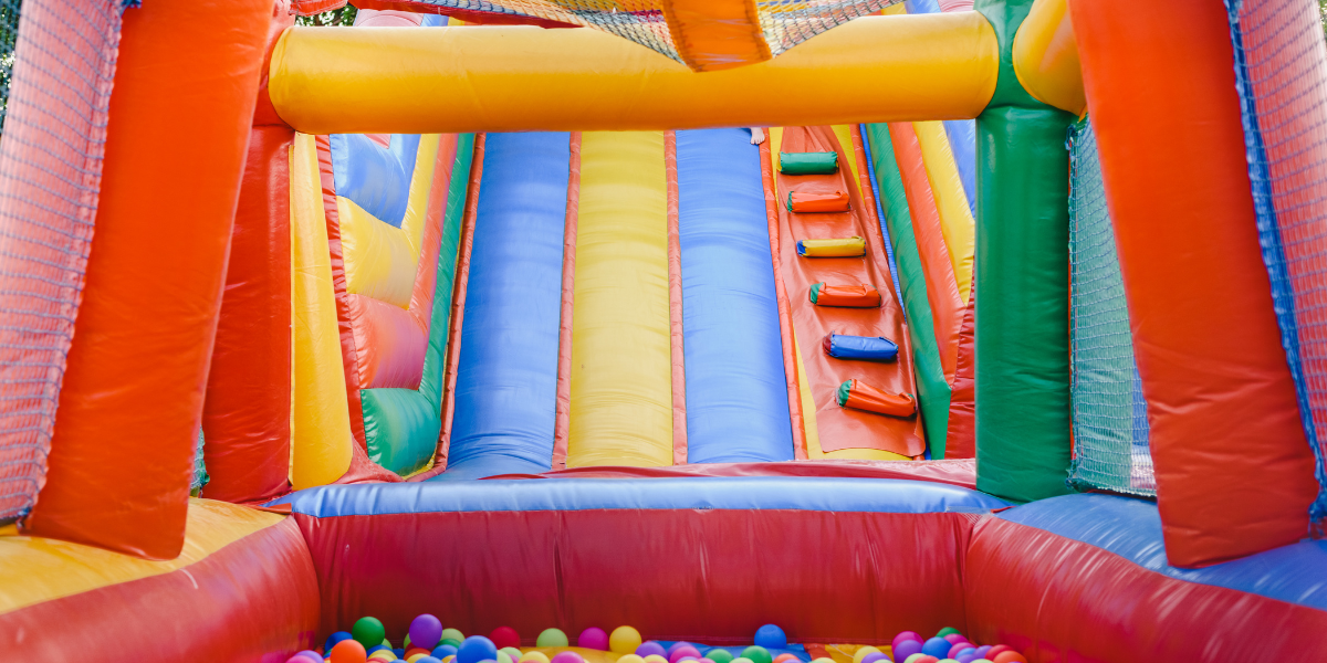 Close-up of a colorful inflatable bounce house slide and ball pit with rainbow balls