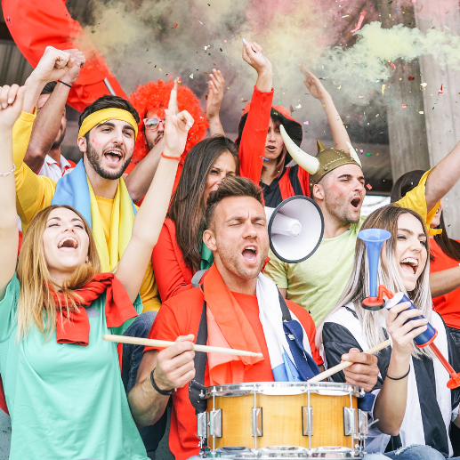 Sports fans cheering in stadium stands with colored smoke flares and a drum