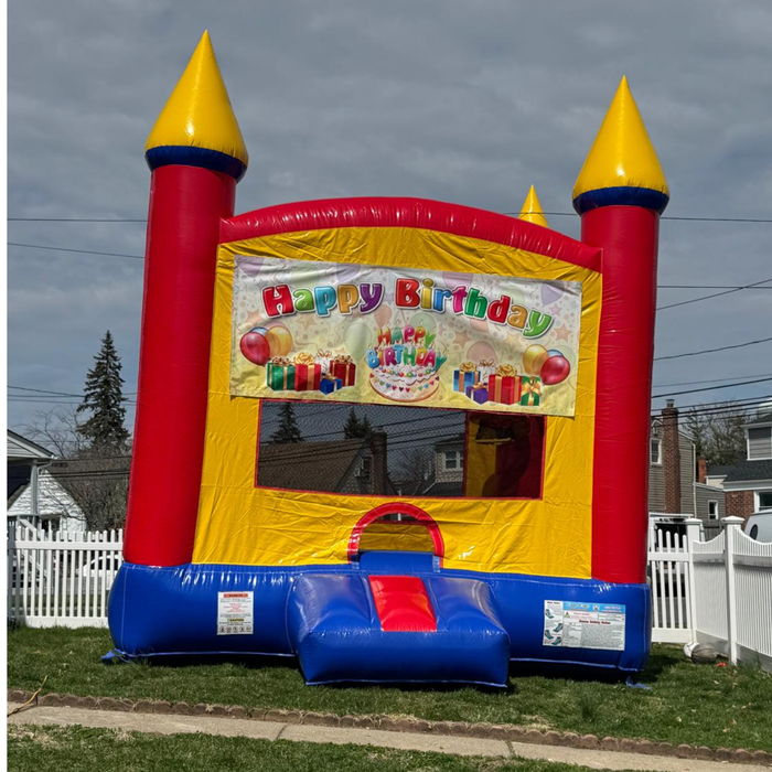 Colorful inflatable bounce house with 'Happy Birthday' sign on a grassy area. Exclusive Beyond Tent Picture. 