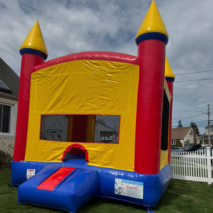 Multicolor inflatable bounce house with red, yellow, and blue colors on a grassy area.