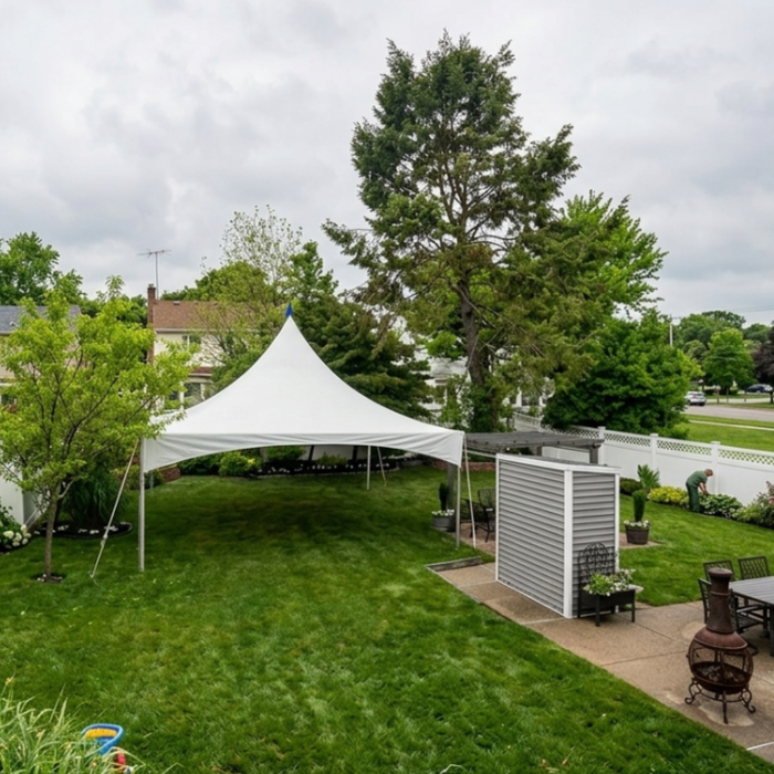 Eye-level front view of a commercial 15x20 High Peak frame tent assembled on a green grass lawn, showcasing the elegant sweeping lines of the white tension canopy top.