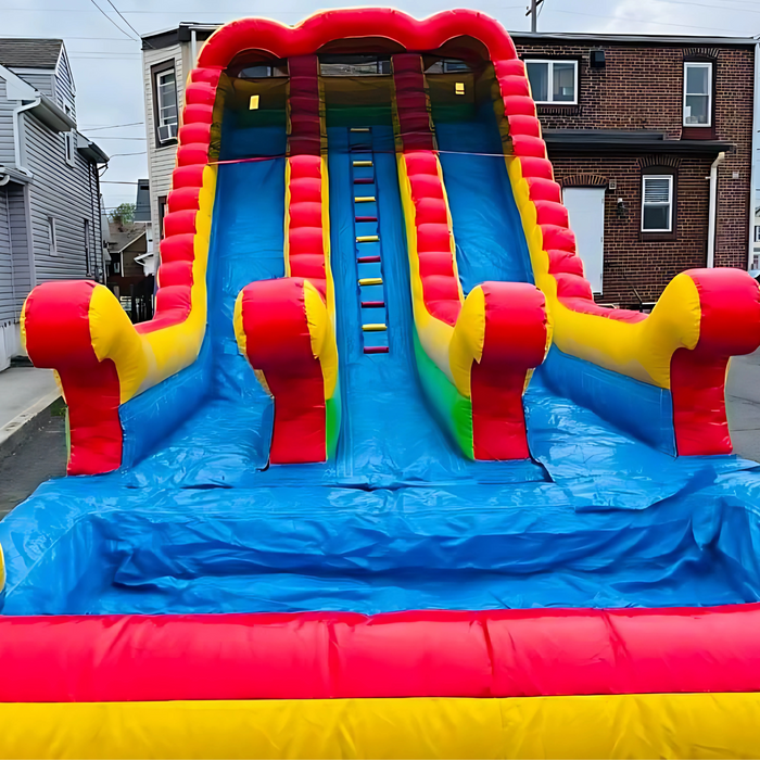 18' 2 Lane Unisex Wet & Dry Slide set up on a residential street, front view, row houses visible in background, overcast sky
