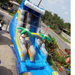 18' Bahama Blast Water Slide installed on a residential street driveway, stop sign and parked truck visible in the background