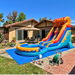 Beyond Tent 18' Magma Lightweight Volcano Water Slide with Pool, orange and blue lava-themed water slide with splash pool set up on a backyard patio next to a house with a tile roof and umbrella table