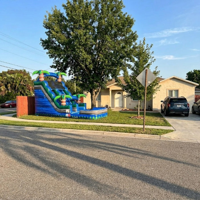 Wave Run Slide in a front yard, sunny day. White house with Concrete driveway. 
