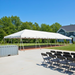 Beyond Tent 20x60 Classic Series West Coast Frame Tent setup outdoors with black folding chairs arranged in rows in front