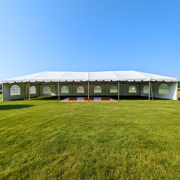 Beyond Tent 20x60 Classic Series West Coast Frame Tent setup on grass with white Cathedral window sidewalls and a wood dance floor visible inside
