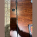 Long metal rod with a round disc on a wooden surface