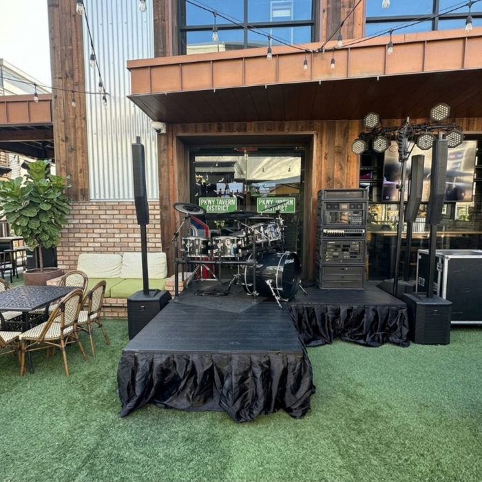 4'x4' Portable Stage Platform | Heavy-Duty Commercial Beyond Tent exclusive picture. 
Outdoor event setup with stage, chairs, and tables in an urban setting.