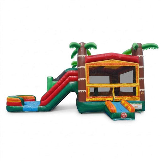 Beyond Tent Tiki Trail Dual Lane Wet and Dry Combo on white background — full unit from front-left angle. Left: dual-lane water slide with side-by-side red and green slide lanes descending to a multi-color striped oval splash pool. Right: large bounce house with yellow-orange walls, mesh viewing window, and brown tiki-column corners with white sawtooth trim. Three oversized green palm trees crown the peak. SKU 2M-2LPBC.