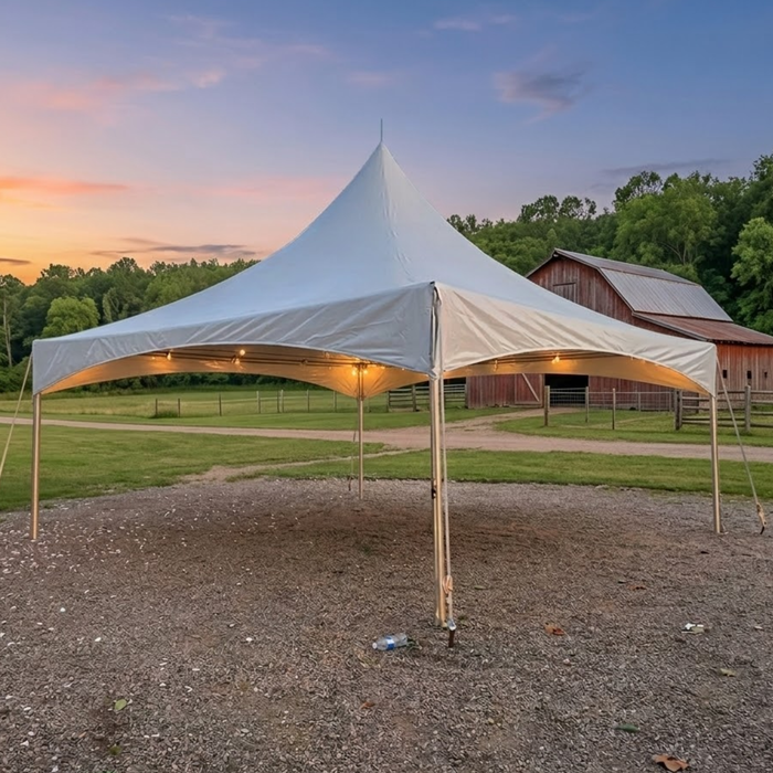 20x20 High Peak Frame Party Tent with string lights set up on a gravel driveway near a red barn at sunset.