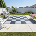 Checkered outdoor rug on a patio with chairs and a cart in a backyard setting.