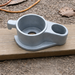 Metal base plate bracket on a wooden surface with a natural outdoor background