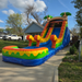 Colorful 16' Sunset Slide  inflatable water slide on a driveway with a house in the background
