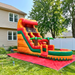 Colorful inflatable water slide on a grassy lawn with trees in the background