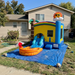 Inflatable bounce house with slide and pool in front of a house
