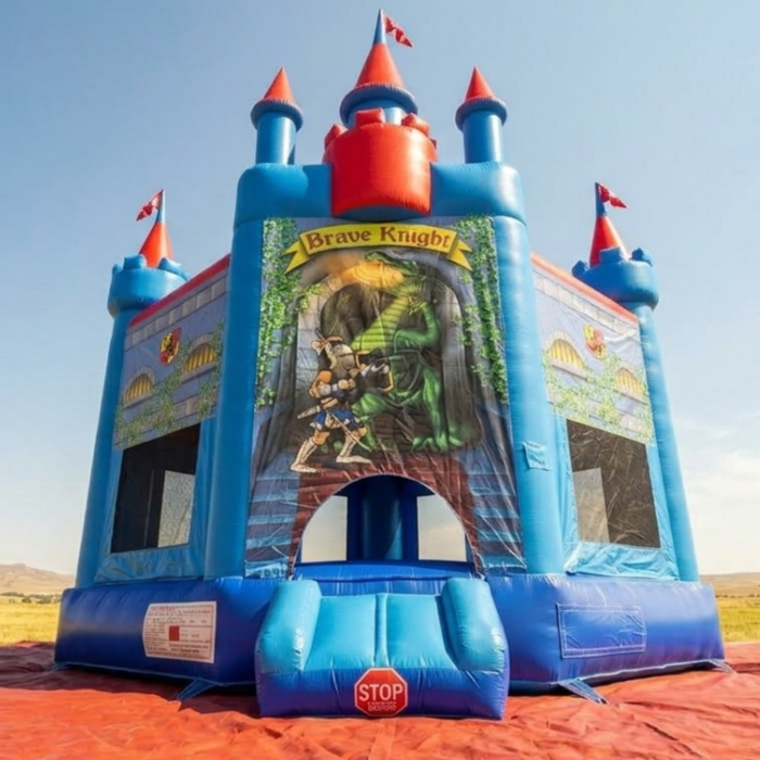 Beyond Tent Blue & Red Medieval Castle Jumper with Blower, Brave Knight bounce house set up on a red tarp in an open field with distant hills in the background