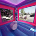 Second interior view of the KPOP Combo bounce chamber showing pink and purple interior walls, a basketball hoop in the center, and large finger-proof mesh netting windows on the sides allowing natural light in and giving supervisors clear visibility into the bounce area from outside. Asphalt surface visible through the mesh.
