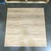 Light natural oak wood-grain interlocking dance floor tile shown from above on a grey concrete warehouse floor, near wooden shipping pallets
