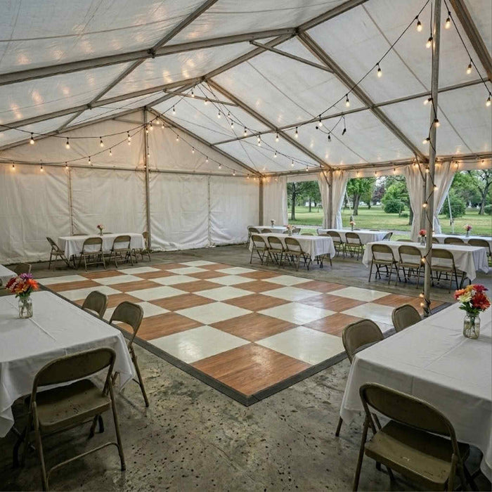 Tented event space with tables, chairs, and string lights. Natural White Dance Floor set up. 