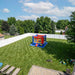 Beyond Tent Knockout Zone 15ft Commercial Boxing Bounce House, aerial drone view of the bounce house set up in a large fenced backyard with a patio and kids' toys nearby