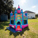 Beyond Tent Lightweight Hawaiian Castle Bounce House with Blower set up in a backyard with a storage shed, mature trees, and a two-story house in the background