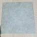 Beyond Tent Natural Grey Vinyl Flooring Commercial Grade sample swatch with mottled concrete-look texture on a light oak wood plank floor