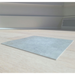 Natural Grey Vinyl Flooring CommercialGrade_2 placed on a light wood floor in an indoor room setting, with baseboards and a vent visible in the background.