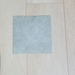 Natural Grey Vinyl Flooring | Commercial Grade
tile or flooring material placed on a light beige wood plank surface.