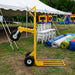 Beyond Tent picture of the dolly on grass with chiavari chairs, pole tent and inflatables behind. 