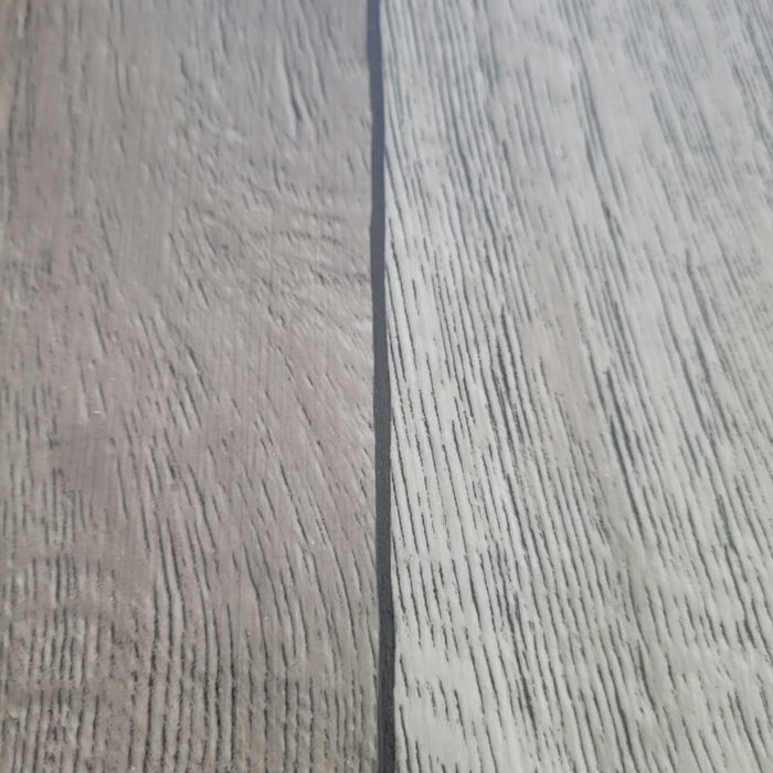 Close-up of the seam between two planks of Beyond Tent Silver Oak commercial-grade vinyl flooring, showing matched wood-grain texture