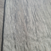 Close-up texture detail of Beyond Tent Silver Oak commercial-grade vinyl flooring, showing the realistic wood-grain surface pattern