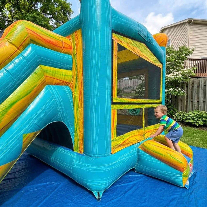 Beyond Tent Solar Dual Lane Combo bounce and climb entry area with mesh safety windows, teal and yellow marbled vinyl, child climbing into the unit in a backyard with wood fence