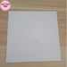 Matte White Rolled Vinyl Flooring sample swatch on a light oak wood table, pink Exact Color Finish badge in the top left corner