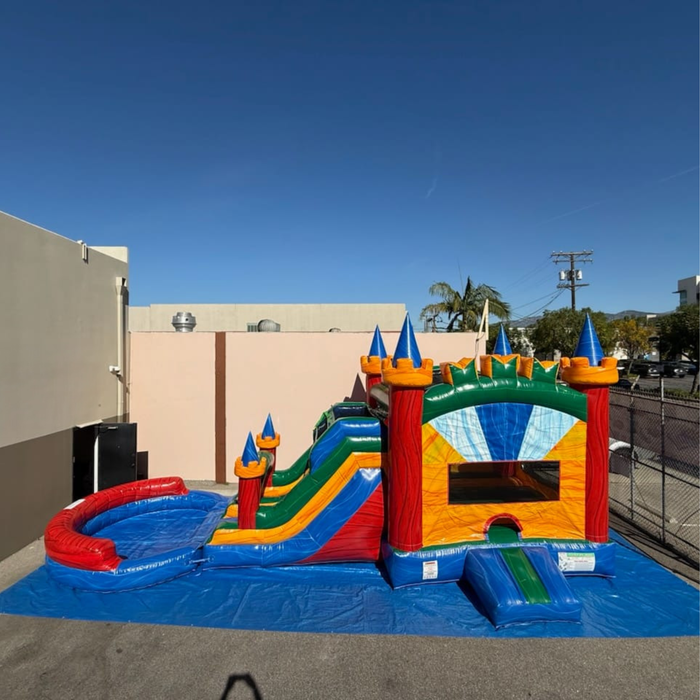 Twin Tower Dash 4-in-1 inflatable combo – full unit showing dual-lane bounce area with mesh windows, castle tower design in red, yellow, green, and blue, with attached water slide and splash landing zone
