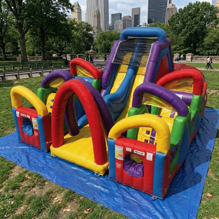 Colorful inflatable playground structure in a park with city skyline in the background