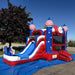Front three-quarter view of the American Titan Wet and Dry Combo on a blue tarp in a parking lot, star-covered blue towers with striped domes, red marble base, slide and entrance ramp