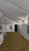 Interior walking view of a 20x30 white frame tent, showing the clear-span anodized aluminum structure and 16 oz. blockout vinyl top with sidewalls installed